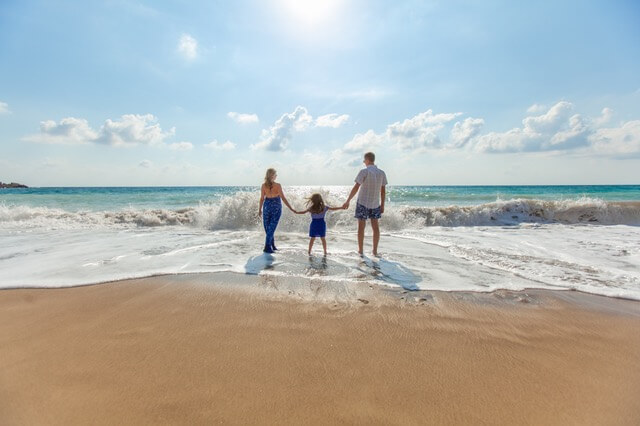 family holding hands on the beach