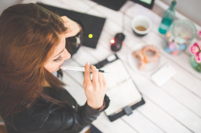 person sitting at desk with pen