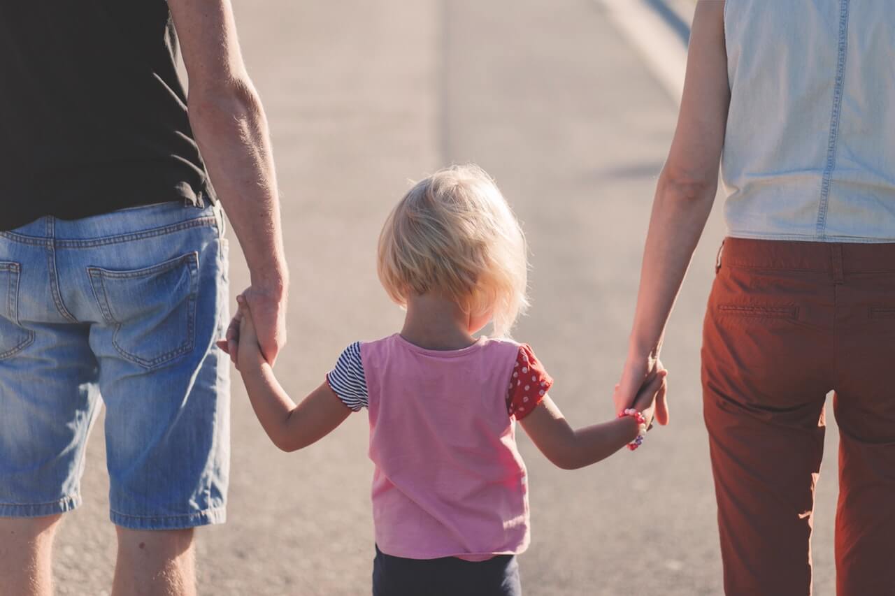 two people holding hands with child
