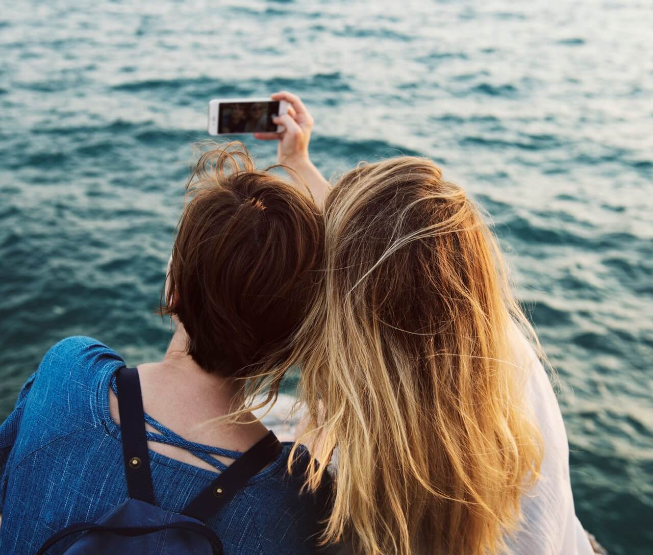 two people taking a selfie by water