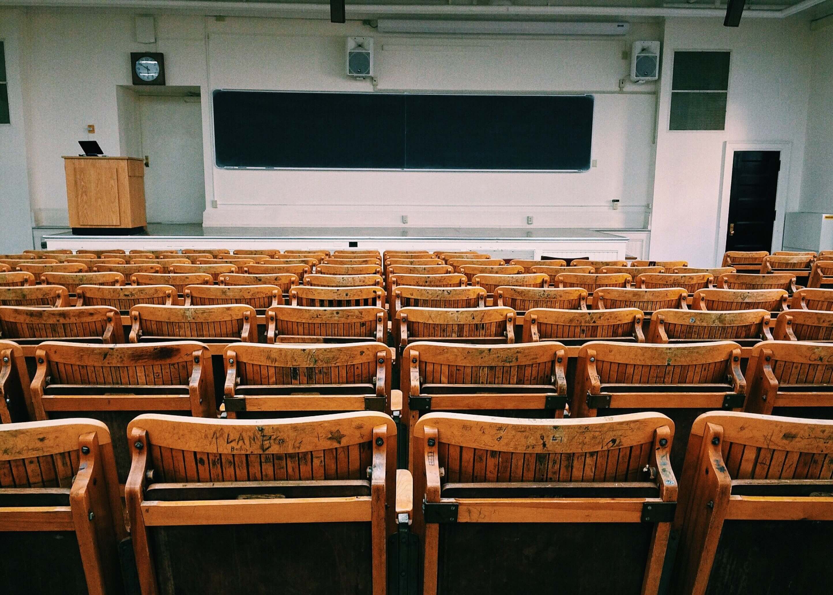 lecture hall classroom of chairs pointing towards the front of the class