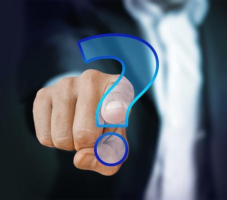 person in a suit pointing to a question mark