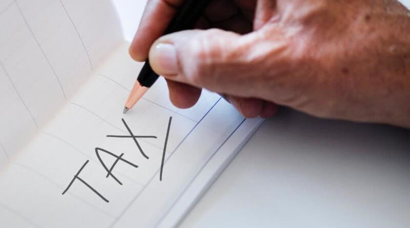 person writing down TAX